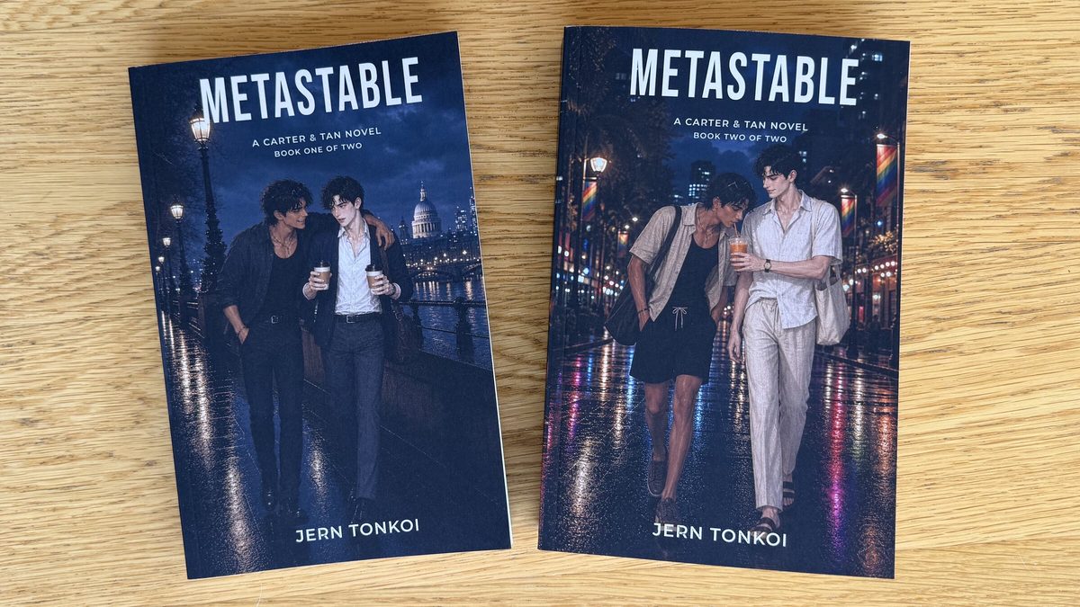 Paperback copies of Metastable: Book One of Two and Book Two of Two arranged together on a wooden surface.